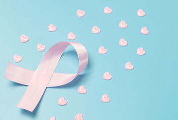 One pink ribbon with hearts on a blue background.