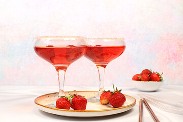 Festive alcoholic cocktail, red martini in glasses on a bright background with strawberries, summer bar concept, alcoholic drinks at a party, restaurant and cafe advertising, selective focus.