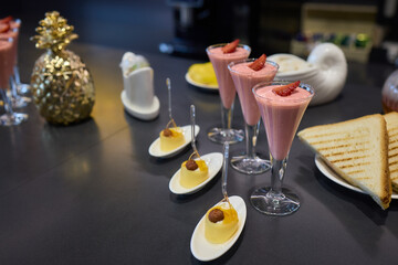 Assorted pastries such as jam tarts and layered desserts beautifully presented on slate trays