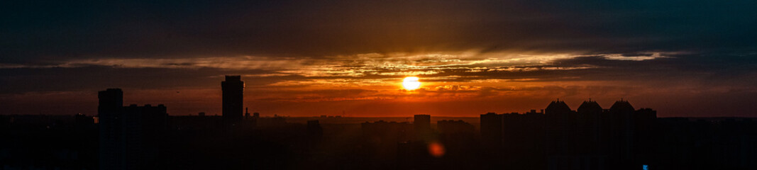 Setting sun over a big city, Panoramic photo, selected focus.