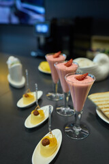 Assorted pastries such as jam tarts and layered desserts beautifully presented on slate trays