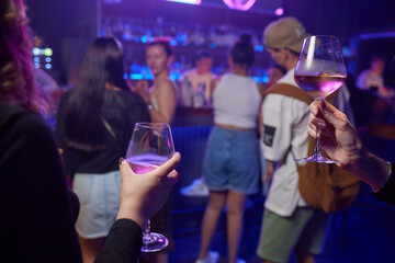 At a lively nightclub, people are enjoying wine and socializing in a chic ambiance