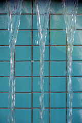 Water cascading over the edge of a turquoise tiled fountain