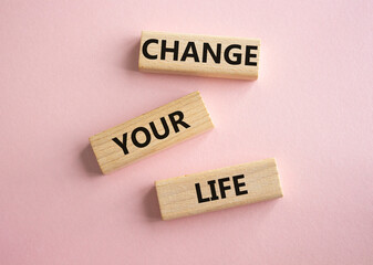 Change your Life symbol. Wooden blocks with words Change your Life. Beautiful pink background. Business and Change your Life concept. Copy space.