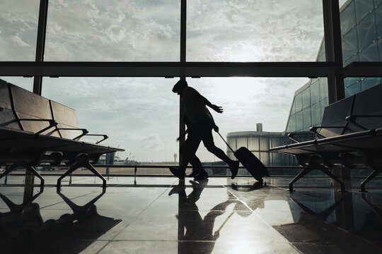Couple of passengers run through the airport to avoid missing the flight.