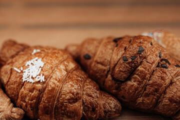 Close up two freshly baked french croissants. Assortment of baked goods on the counter