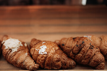 Close up three freshly baked french croissants. Assortment of baked goods on the counter