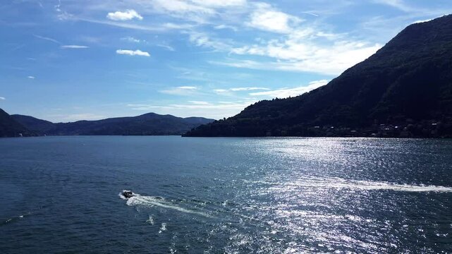 breathtaking tracking shot of aerial view of fast motorboats and slow old boats crossing themselth on water Como lake on a summer morning 8