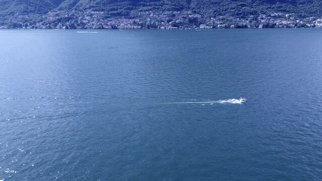 breathtaking tracking shot of aerial view of fast motorboats and slow old boats crossing themselth on water Como lake on a summer morning 4