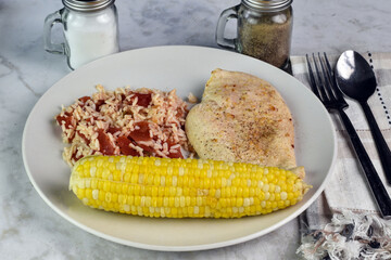 seasoned chicken breast with rice and corn,.