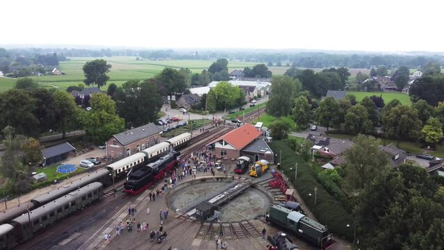 Beekbergen, the Netherlands - August 6th, 2023: Ascending drone footage of people lining up to see a steam locomotive on the local marshalling yard before it leaves on a trip to nearby Dieren.
