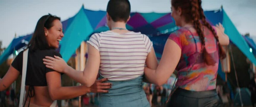 Excited female friends hugging at a festival