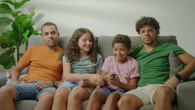 Same Sex family, siblings fighting over TV remote control at home
