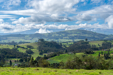 Obraz premium Country landscapes with farms between trees and mountains.