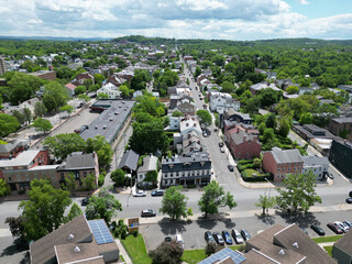 aerial view of hudson, new york (small hudson valley town city downtown historic district) mountains catskills ny travel destination main street with hills clouds cars tree matter