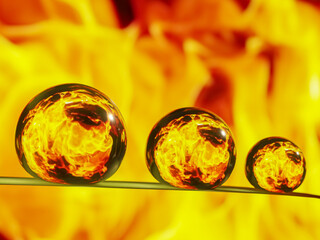 Closeup shot of three water droplet formed on a grass blade with fire reflection inside the drops