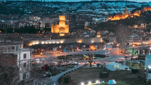 Tbilisi, Georgia. Scenic View Of Park Rike In Tbilisi, Georgia. Metekhi Church, Narikala Fortress, Old Historic District Of Kala, Cableway, air balloon viewpoint. Urban Night Cityscape. Evening Scenic