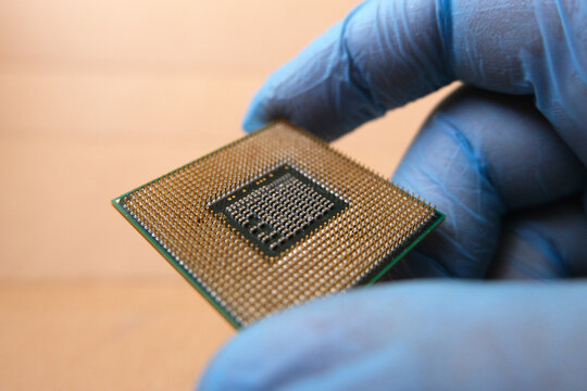 Close up of a technical personnel holding a micro processor.