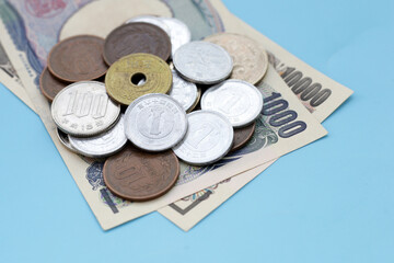 Japan money, banknotes with coins on blue background.