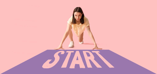 Sporty young woman getting ready to run on pink background