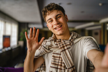 Self portrait of young happy caucasian man indoor