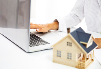 Real estate agent working with laptop at table in office.hand using laptop and calculator