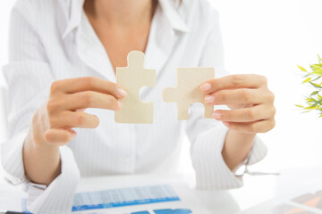 Business woman person hand holding puzzle piece idea for strategy and solution. Closeup part of two...