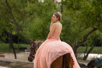 Fototapeta premium Girl in prom dress riding a horse