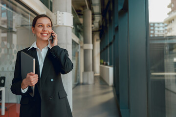 In a modern office, a successful businesswoman is confidently engaged in a phone call