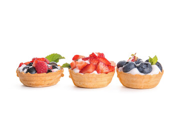 Tasty tartlets with whipped cream and berries on white background