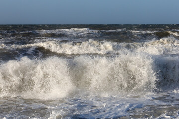 Brandung mit Gischt am Strand der Ostsee von Dazendorf bei Heiligenhafen, Schleswig-Holstein bei starkem Wind.