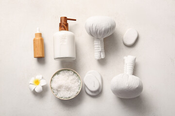 Beautiful spa composition with herbal bags, stones and bottles of cosmetic products on white background