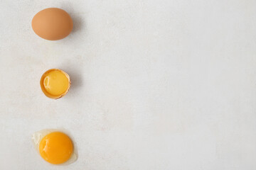 Cracked and whole chicken eggs on white background