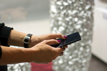 Woman with Red Nails Using a Smart Phone in the Street