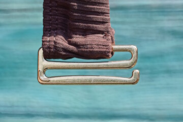 one yellow metal clasp on a brown fabric strap on clothing