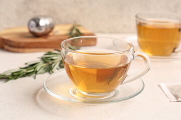 Glass cups of hot rosemary tea on white background