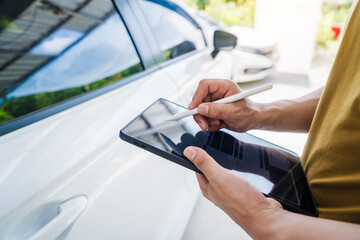 Man fills out a car insurance form after a car accident. Comprehensive motor insurance covers car...