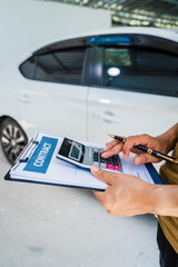 Man fills out a car insurance form after a car accident. Comprehensive motor insurance covers car damage. He files a claim report, speaking with an adjuster to understand his coverage and deductible.