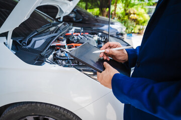 businessman in suit discusses claim with car auto insurance agent. review car damage and complete...