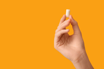 Teenage girl with chewing gum on yellow background, closeup