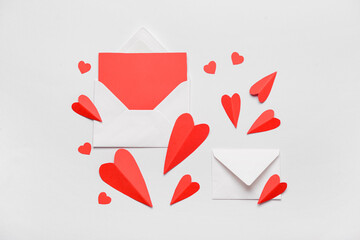 Envelopes with blank card and red paper hearts on white background. Valentine's Day celebration