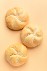 Delicious kaiser rolls on beige background