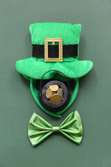 Pot with golden coins, bow tie and leprechaun hat on green background. St. Patrick's Day celebration