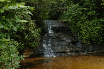 Beautiful large waterfall between green trees in the mountains. Mountain landscape with a waterfall...