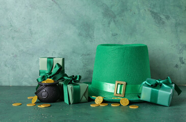 Leprechaun hat with pot of golden coins and gift boxes on green grunge background. St. Patrick's Day