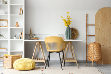 Interior of stylish office with artificial flowers on table