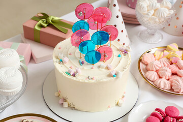 Cake with sweets for birthday party on table