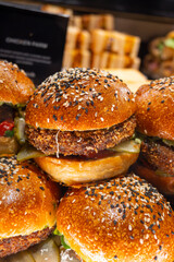 Tasty vegetarian fast or street food, homemade burgers made from orange lentils legumes with onion, green lettuce and tomatoes