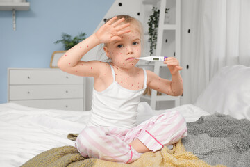 Little girl ill with chickenpox measuring temperature in bedroom