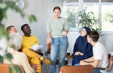 Woman tells an interesting story. Multinational students listening carefully in classroom university